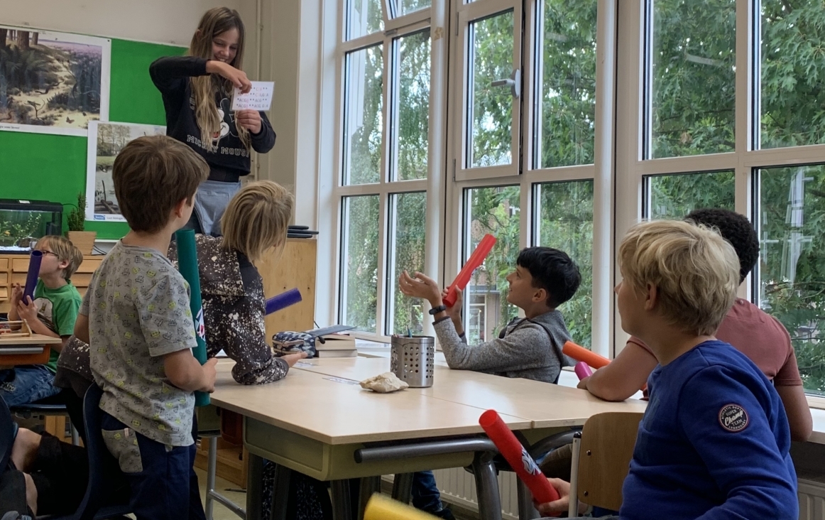 Leerlingen van de bovenbouw begeleiden een rap met boomwhackers.