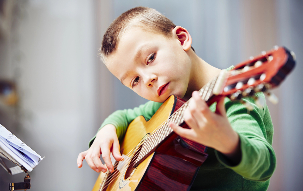 kind speelt op gitaar