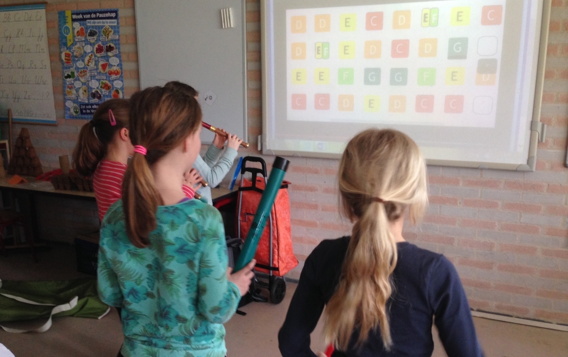 Kinderen met boomwhackers en blokfluit spelen een partituur van Muziek in School. Foto Helga Boekestijn