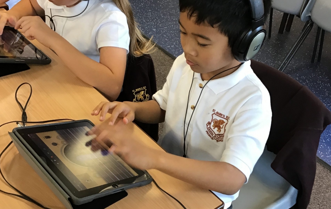 Jongen met iPad maakt muziek