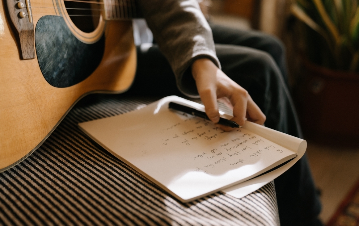 Een liedje schrijven met de gitaar bij de hand. Bron: Pexels Cottonbro