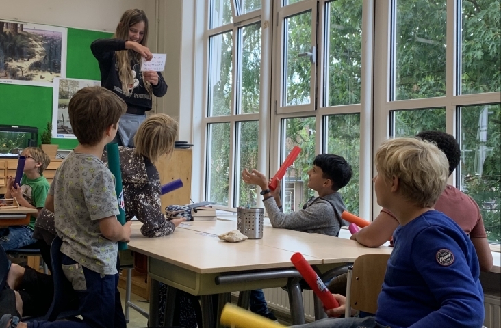 Leerlingen van de bovenbouw begeleiden een rap met boomwhackers.