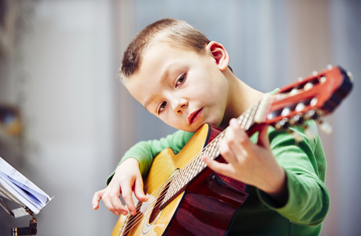kind speelt op gitaar
