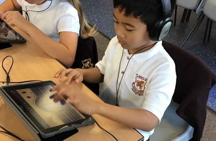 Jongen met iPad maakt muziek
